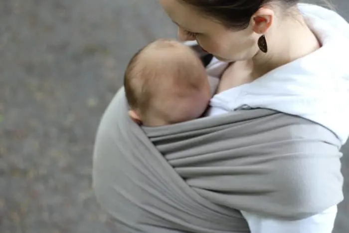 Newborn baby wrapped up inside of a stone gray Boba Wrap