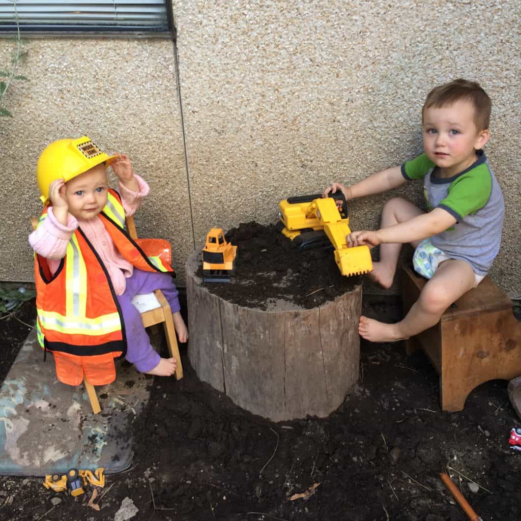 Bob the builder costume on toddlers as they play in the dirt