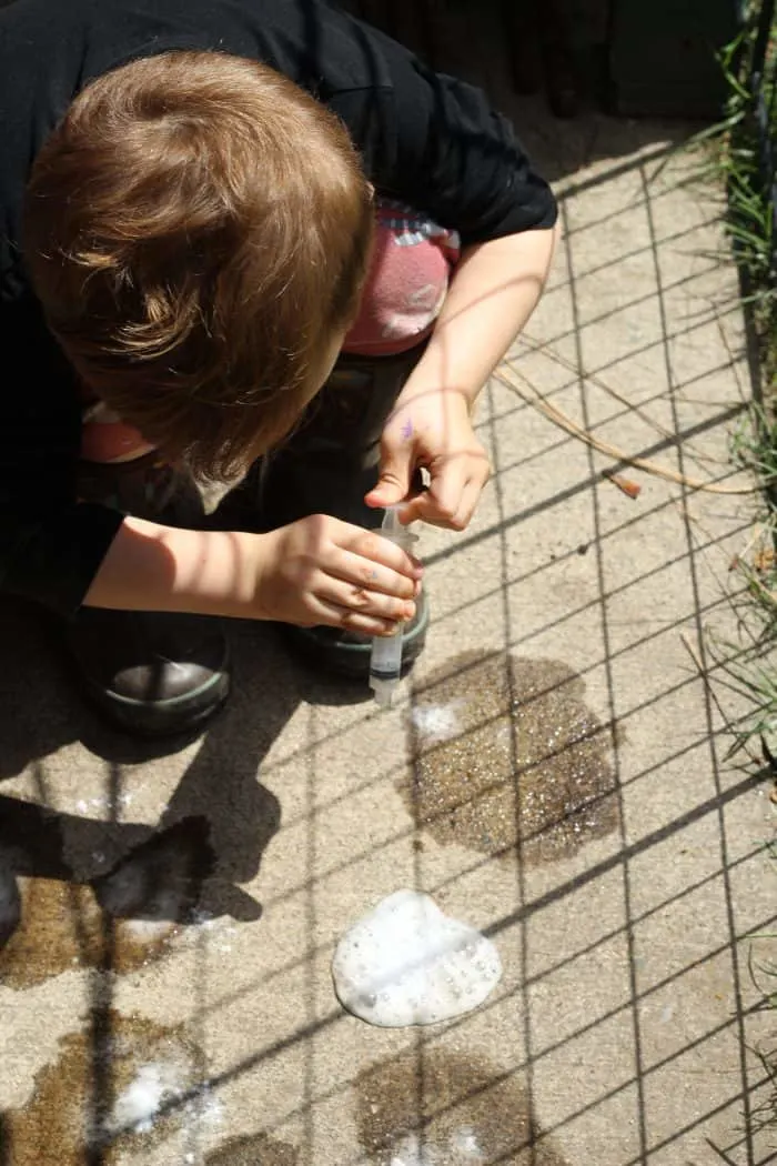 little boy using baking soda and vinegar to see the reaction. #blueandhazel #toddler #toddlercraft