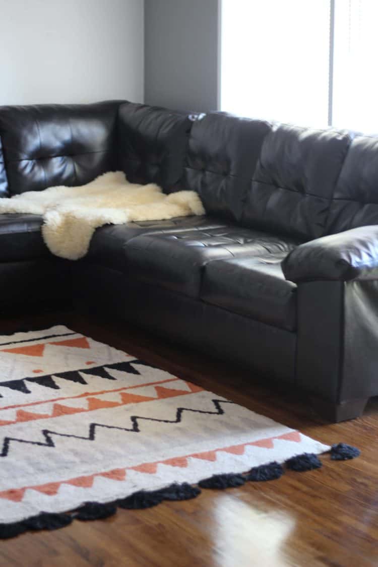 a brown leather couch with a soft lorena canals washable rug