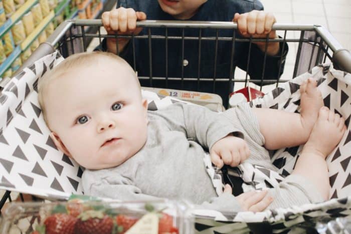 baby boy riding in a Binxy Baby shopping cart hammock in tribal print 