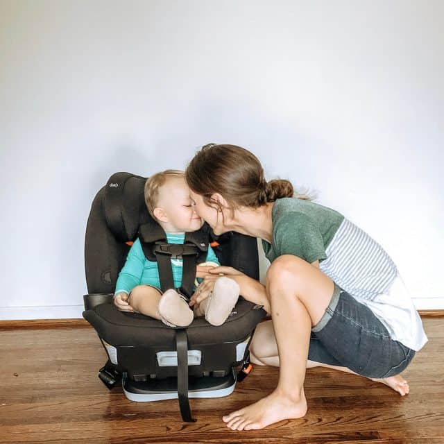 A mom touching noses with her baby while he is strapped into a black Maxi-Cosi Magellan 5-in-1 Convertible Car Seat