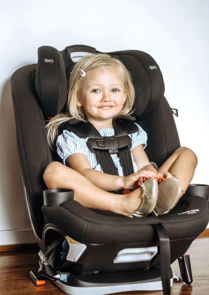 A 3 year old girl stares at the camera while being fit for her new Maxi-Cosi Magellan 5-in-1 convertible Car Seat in Black