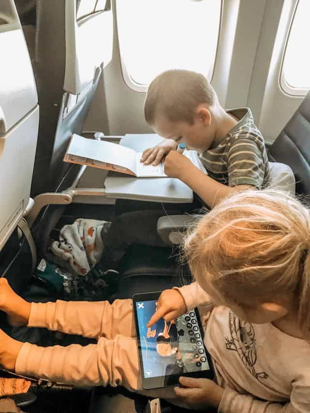 two preschoolers coloring and playing Ipad games during a long flight