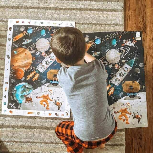 A little boy doing a puzzle of outer space with his dad #blueandhazel 