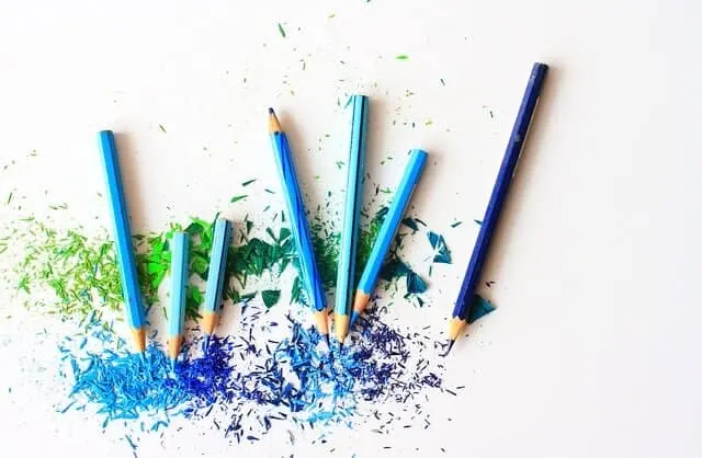 blue and green colored pencil shavings on a white table
