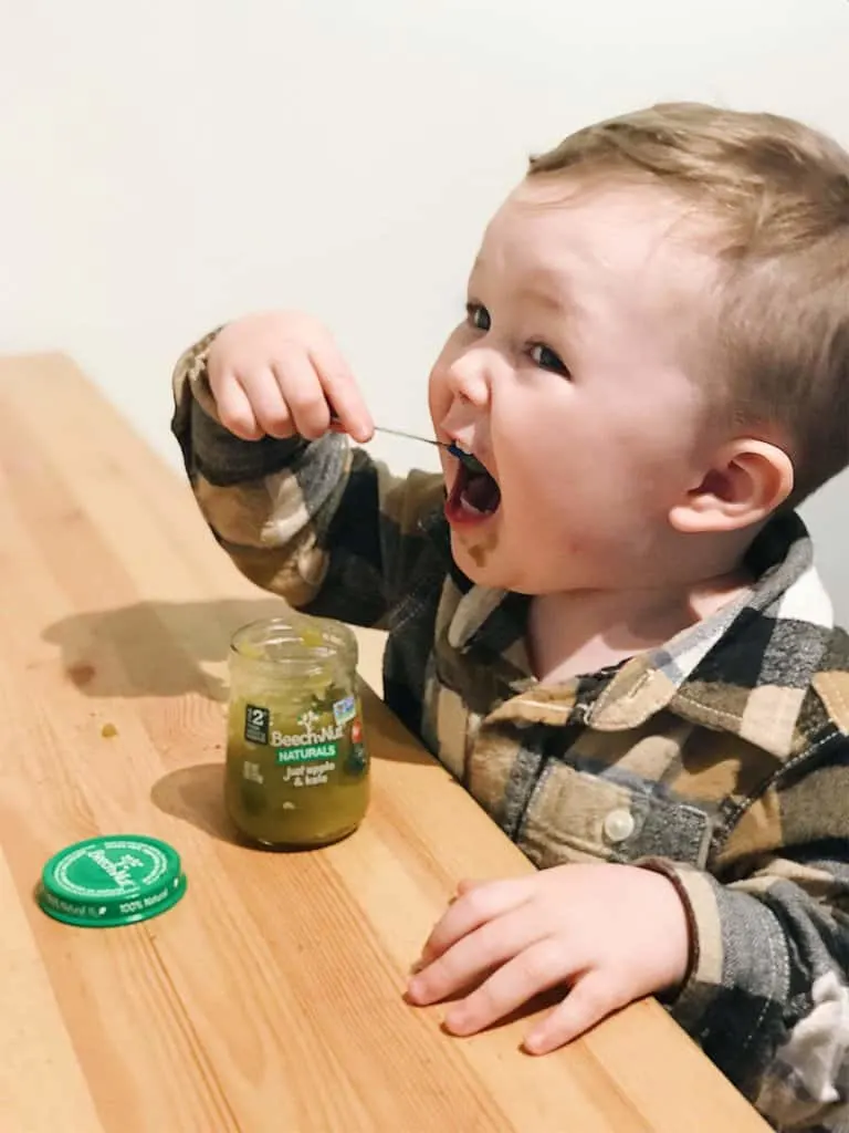 toddler feeding himself beech-nut naturals apple and kale baby food