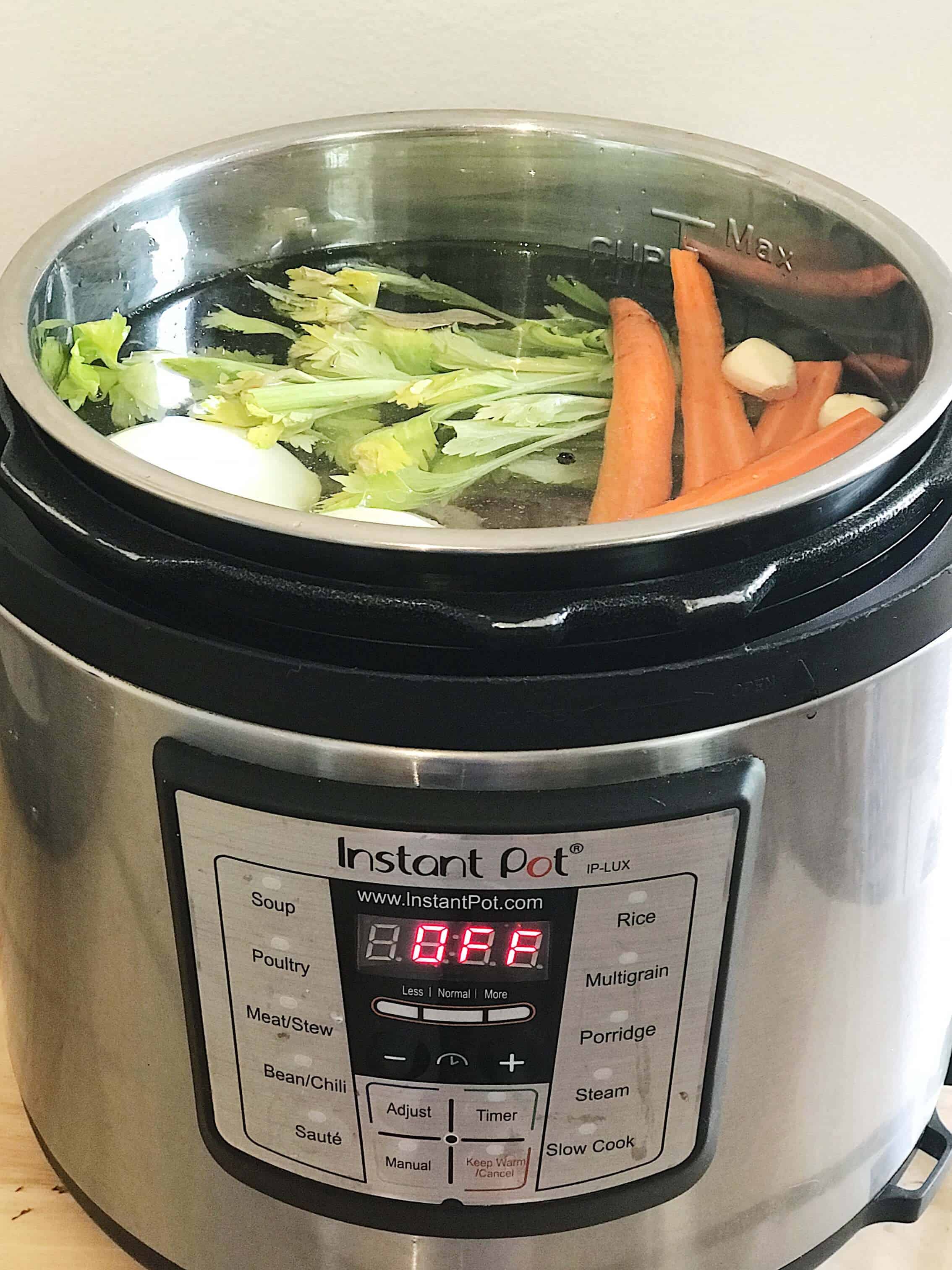 Instant Pot Chicken Stock ingredients inside of the pot filled with water before cooking