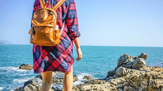 cognac diaper packpack on a girl by the ocean