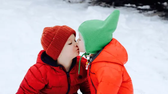 toddler in the snow with his baby sister 18 months apart