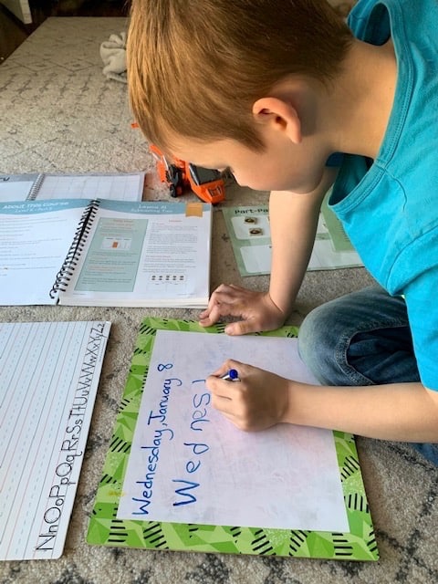 a kindergarten boy writing the date