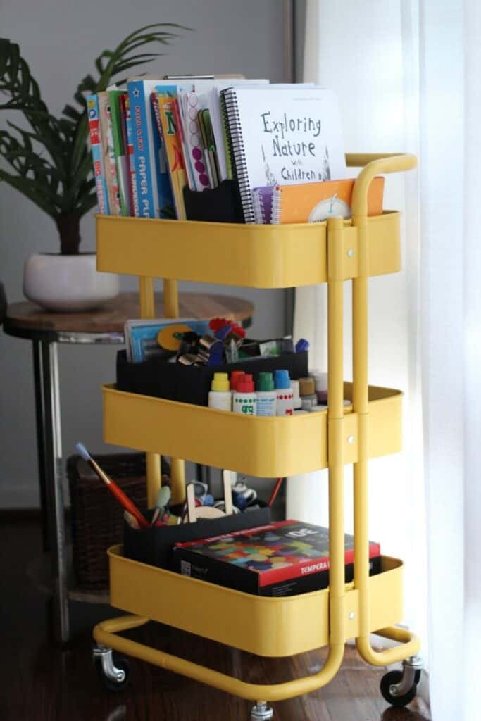 metal yellow cart on wheels holding homeschool supplies