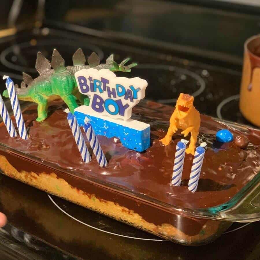 plastic dinosaurs on top of a birthday cake for 6 year old birthday