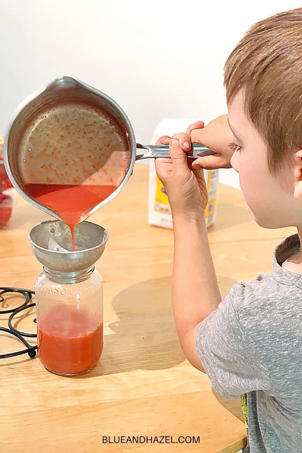 Making low sugar strawberry freezer jam and pouring it into jars. 