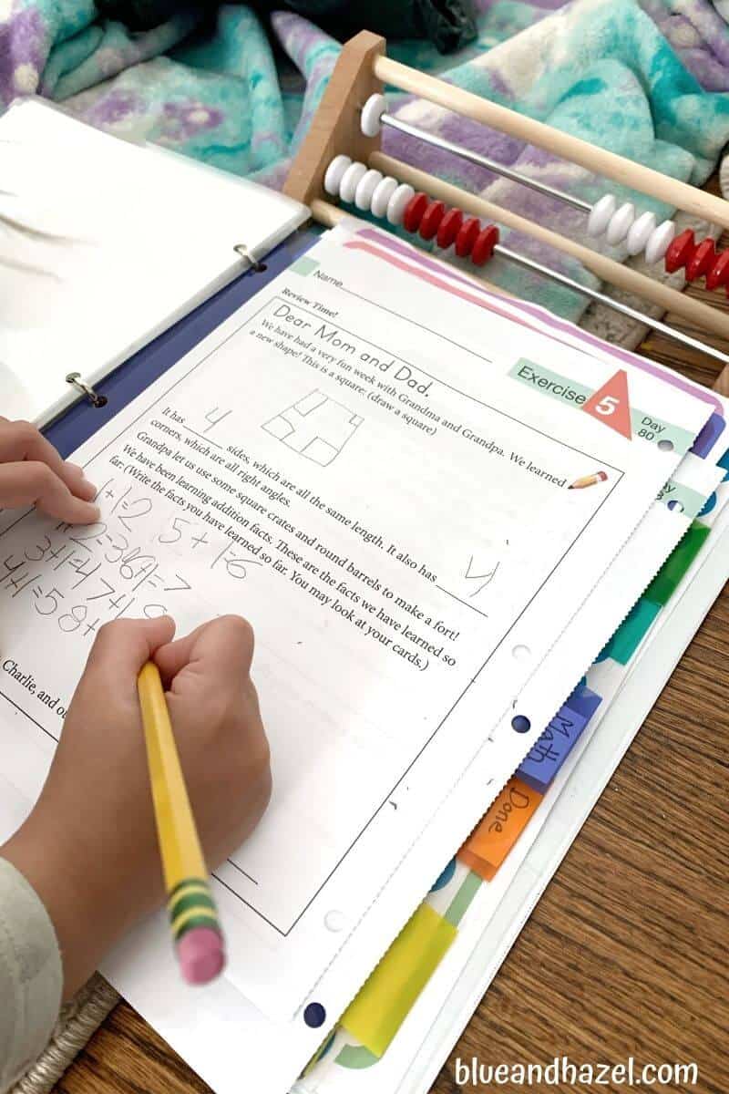 A child finishing up a math worksheet from Math Lessons For A Living Education level 1.