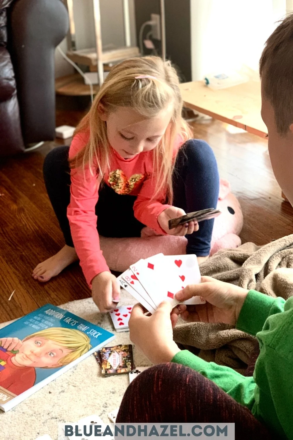 two kids playing card games to learn addition facts.