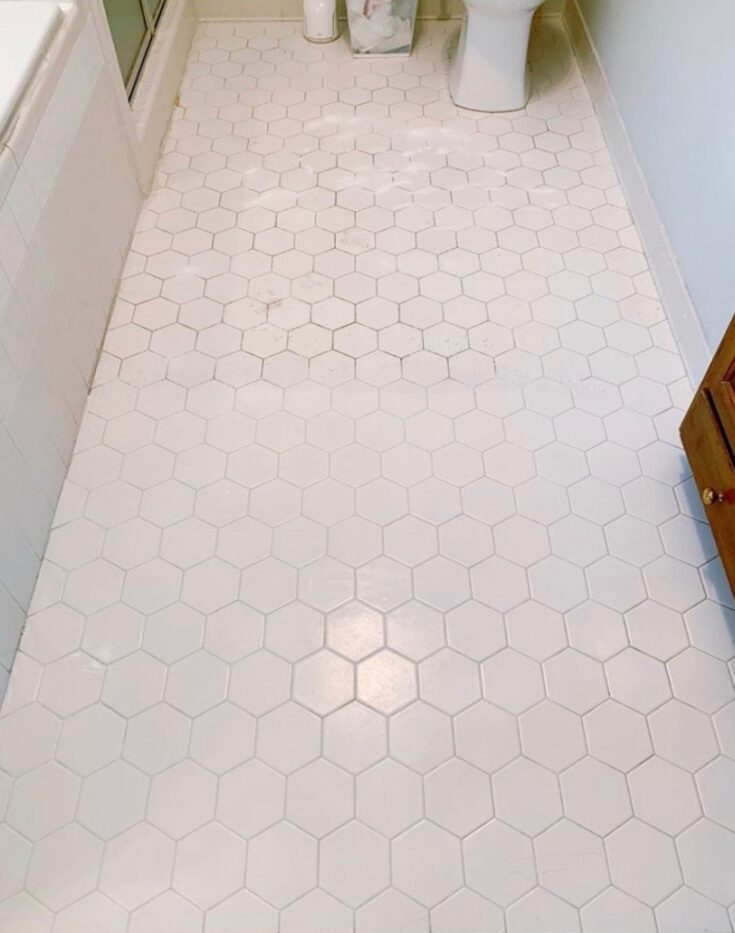 a white tile floor half cleaned using branch basics oxygen boost and bathroom spray. One side is dirty, the other side is white again. 