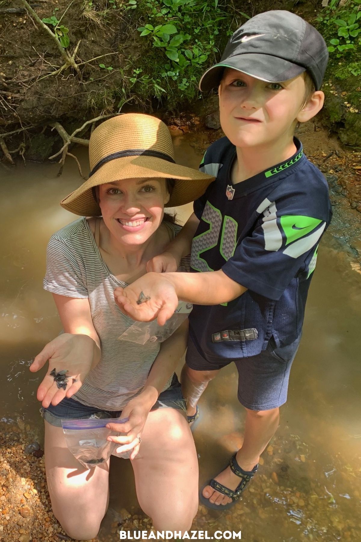 A mother and son holding up their best and biggest shark teeth finds in a creek at Shark Tooth Creek, Alabama