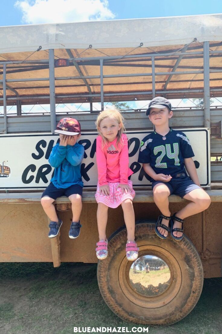 3 kids sitting on the edge of the Shark Tooth Creek Express