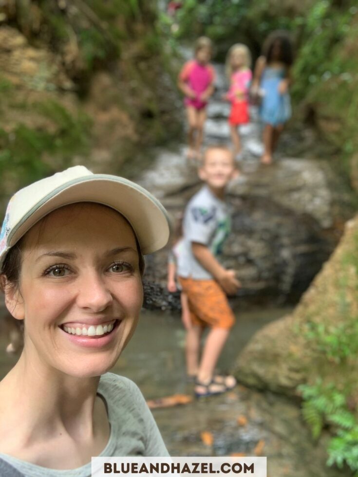 A mother on a nature walk with children in the background