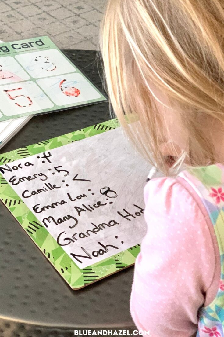 A preschool girl writing counting how many letters are in each friend's name, an activity by Busy Toddler.