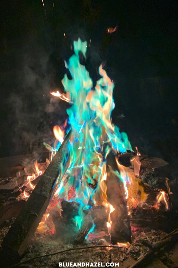 A bonfire with blue and green and orange flames from a special powder that changes the color of flames. 