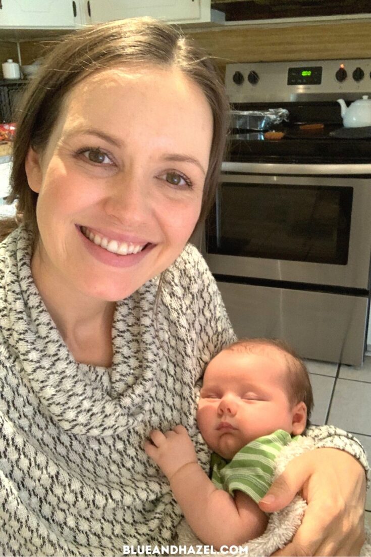 A mother holding her new 4th baby in the kitchen.