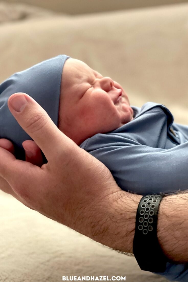 A father holding his newborn son just hours old in his hands. 