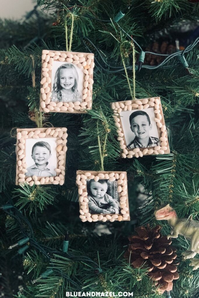 homemade christmas ornaments for kids made out of a photo, cardboard frame, and white beans glued around the edge.