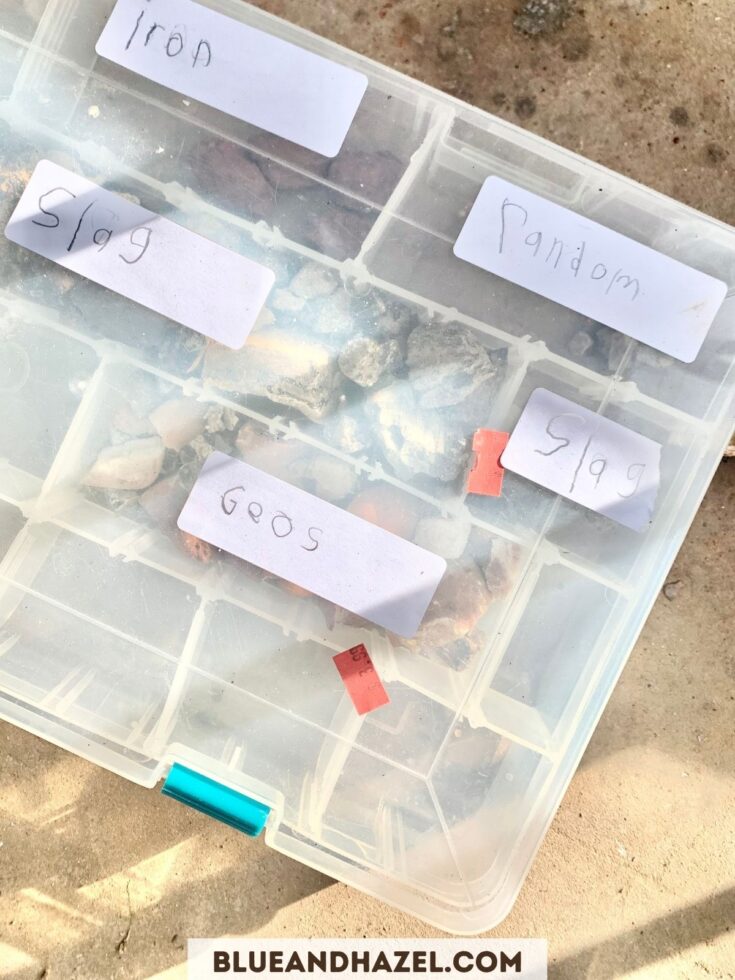 rock collection with geodes, slag, and random rocks in a plastic container with dividers. 