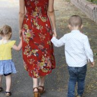 mom walking with two toddlers holding hands