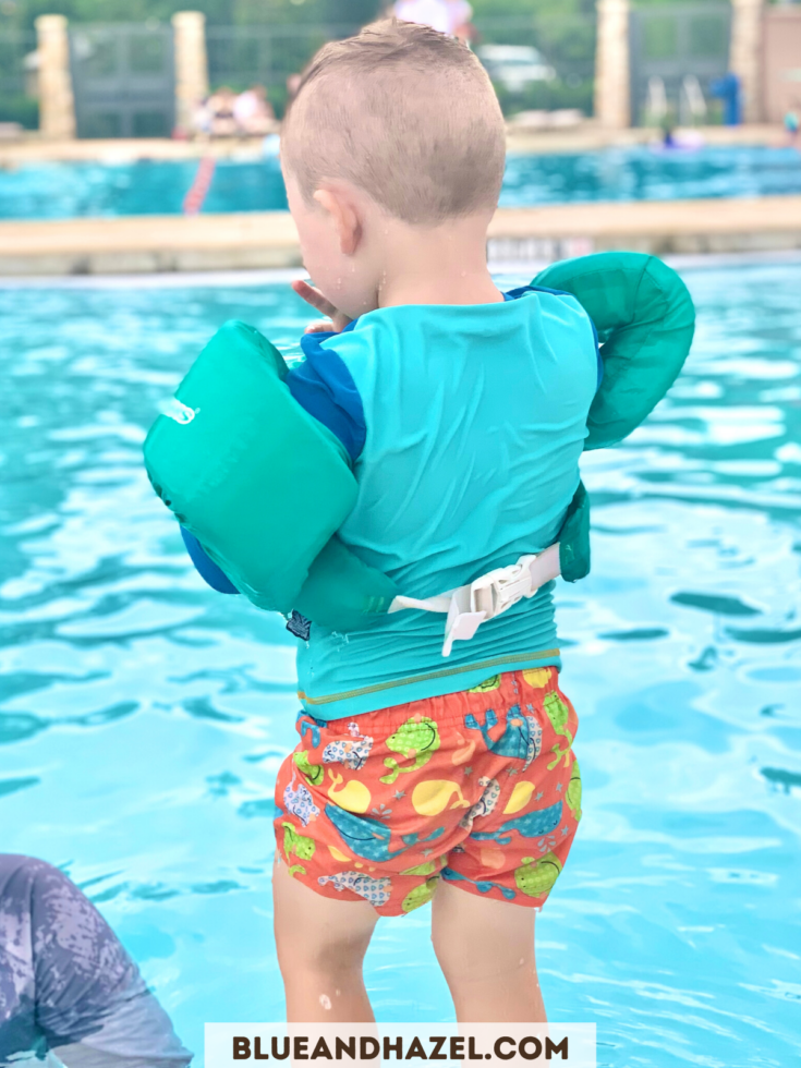 toddler wearing a floatation device at the pool