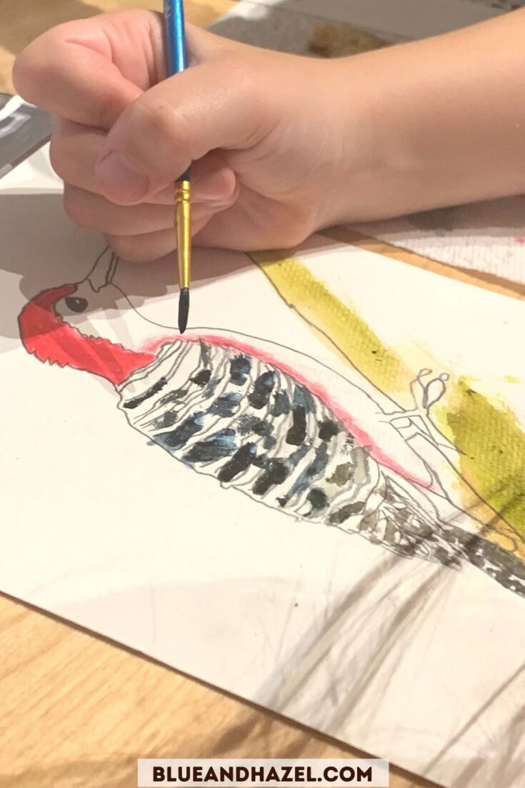 Watercolor of a red headed wood pecker being painted by a child.