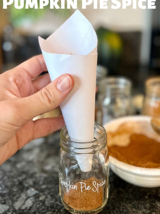 a paper funnel for adding pumpkin pie spice blend into a 4 oz glass Ball spice jar.