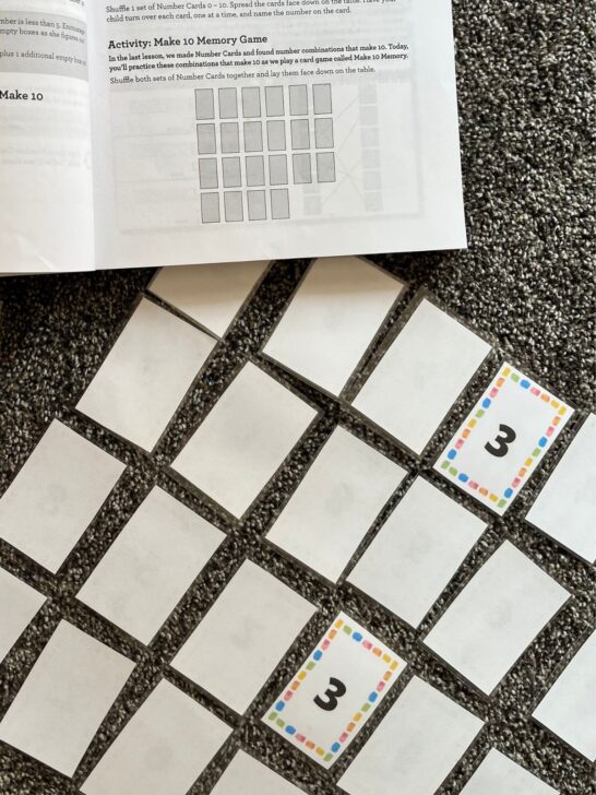 Memory match game laid out on the carpet with a set of 3's showing as part of a kindergarten math lesson.