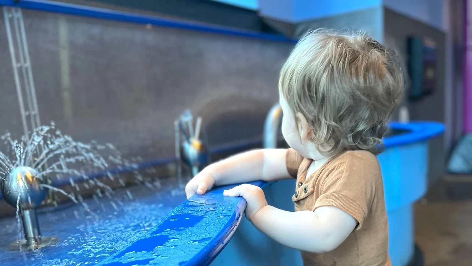 a 1 year old baby splashing in water