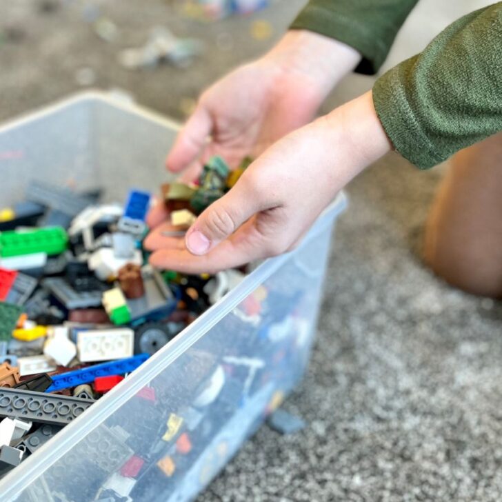 A 9 year old boy picking up Legos as a chore