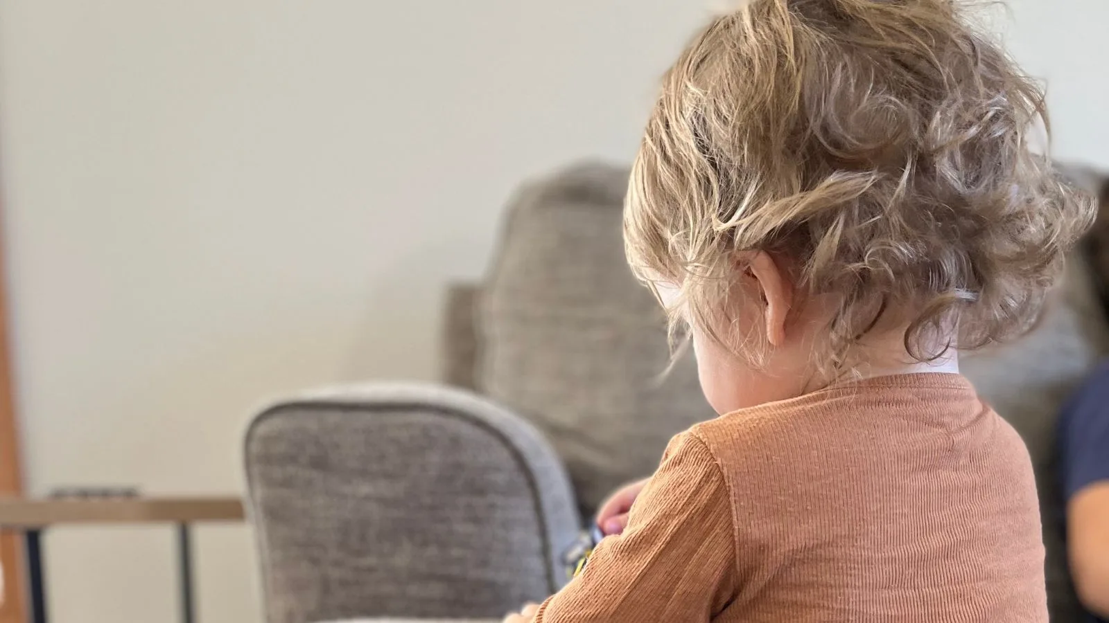 a toddler standing next to a couch