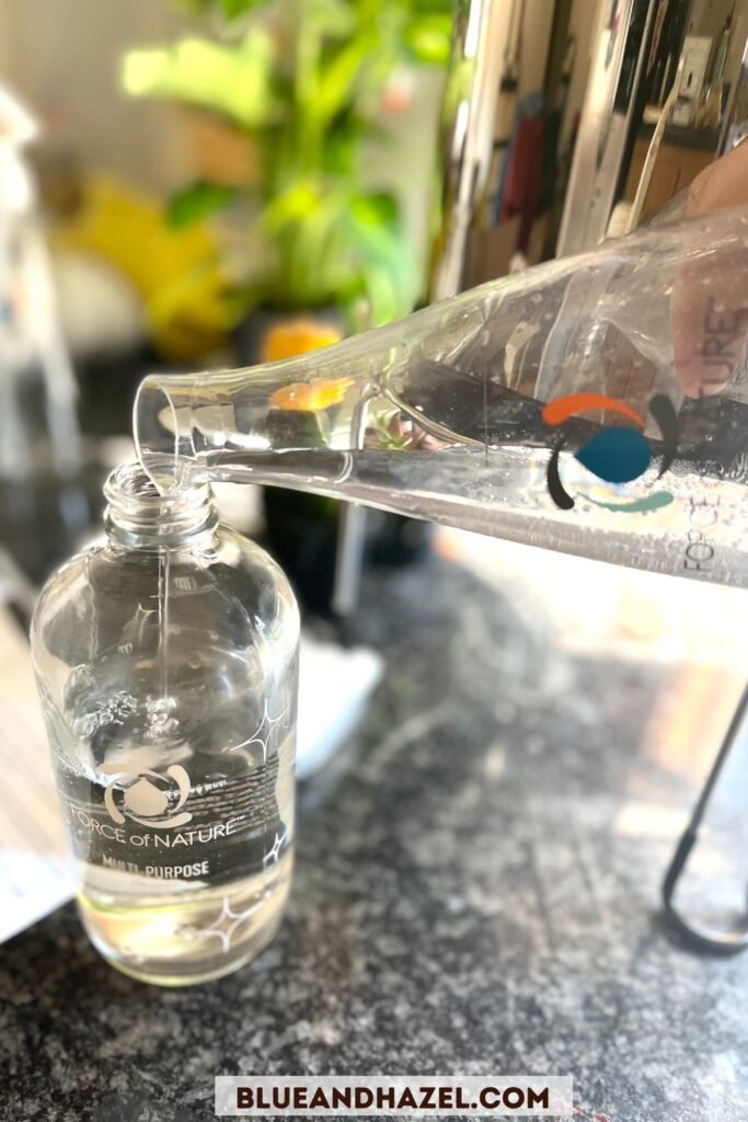 Pouring Force of Nature cleaner from the electrolyzer into the glass spray bottle. 