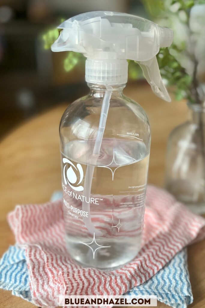 Force of Nature cleaner in the glass bottle on top of a stack of reusable paper towels. 