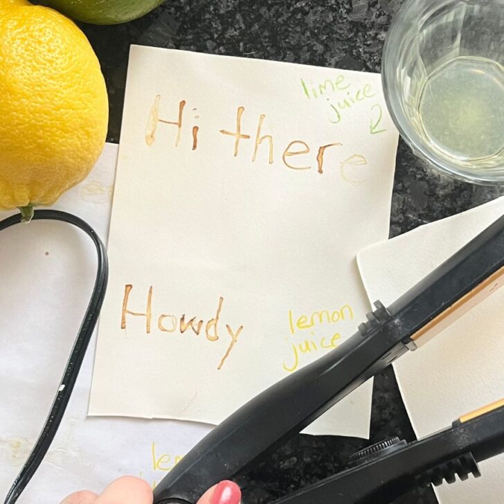 A message using invisible ink made from lemon juice on watercolor paper next to a hot iron