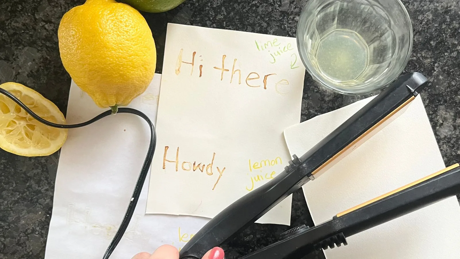 A message using invisible ink made from lemon juice on watercolor paper next to a hot iron