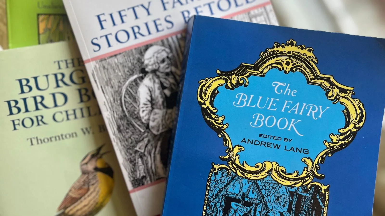 A picture of storybooks from Ambleside Onlineincluding The Blue Fairy Book and Fifty Famous Stories Retold
